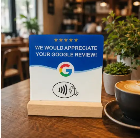 Google review sign with NFC on a wooden base beside a coffee